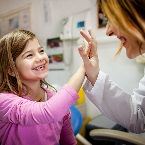 little girl giving dentist a high five